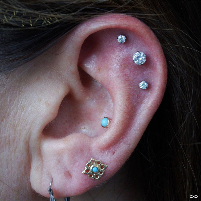 Earlobe piercing with Angela Press-fit End in Gold from BVLA with Turquoise