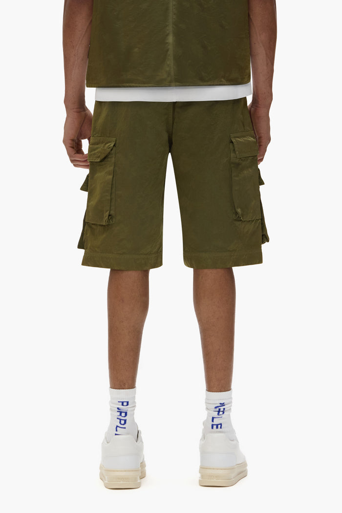 Cargo shorts in green sateen with five-pocket design and utility flap pockets.