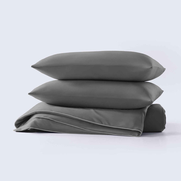 Stacked dark gray cooling pillow shams with soft cooling comforter
