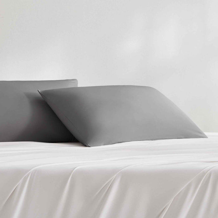Dark gray cooling pillowcases styled on a bed with matching bedding