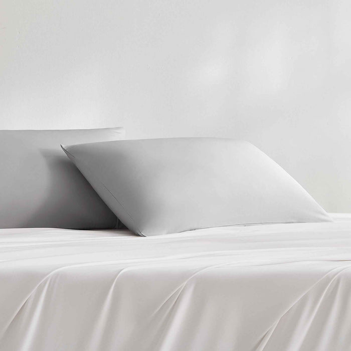 Gray cooling pillowcases styled on a bed with matching bedding