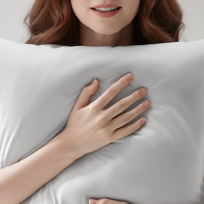 Woman resting on a light gray cooling pillowcase for comfortable sleep