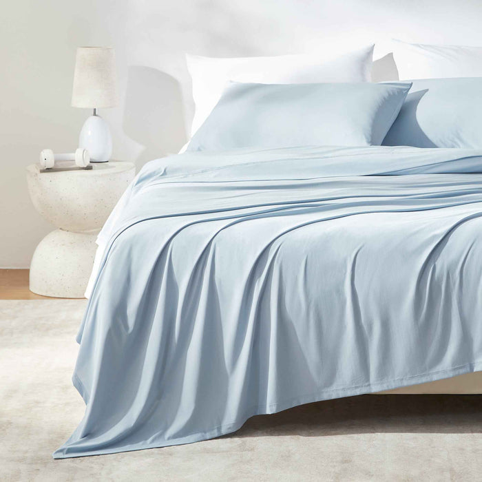 Blue cooling sheet set styled on a modern bed for hot sleepers