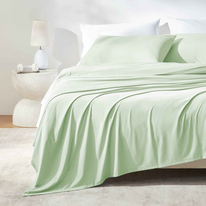 Green cooling sheet set styled on a modern bed for hot sleepers