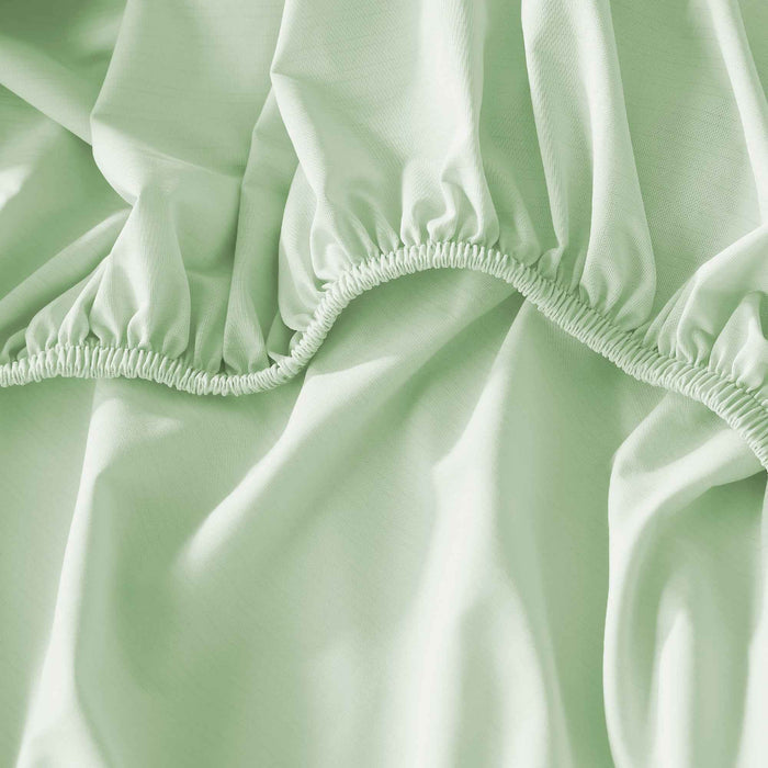 Close-up of silky green cooling sheet fabric with moisture-wicking performance