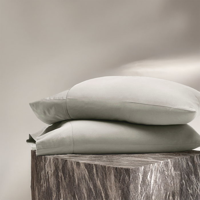 Eucalyptus white pillowcases stacked, showing smooth fabric and subtle sheen.