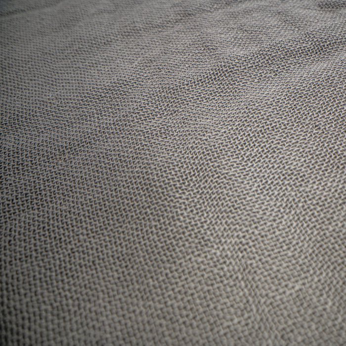 A close-up of a woven fabric texture in a medium gray color, showing the detailed knit pattern.