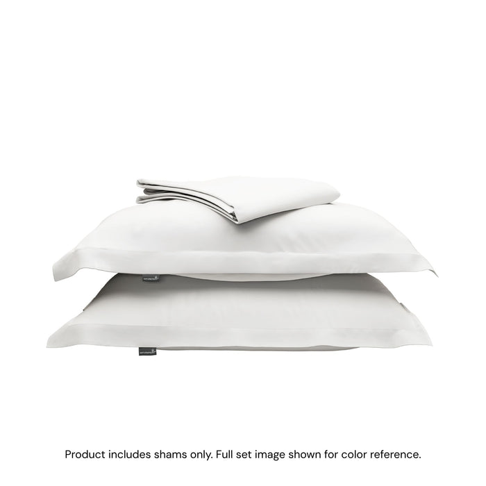 A folded duvet cover on top of two pillow shams. #color_