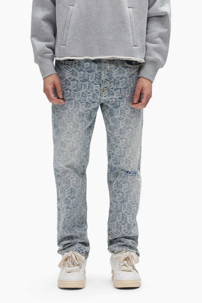 A person wears a gray sweatshirt, white sneakers, and PURPLE BRAND P011 Jacquard Monogram light blue mid-rise straight leg jeans. They stand facing forward with hands at their sides; only their body from shoulders to feet is visible.