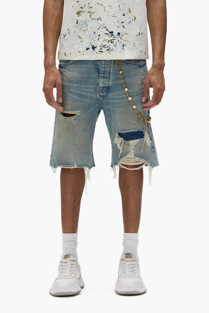 P059 Distressed Patch Shorts in light indigo wash with frayed hems and button-fly closure.