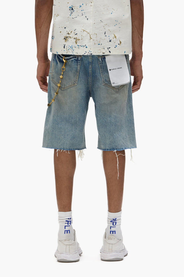 P059 distressed patch cutoff shorts with a light indigo wash and frayed hem details.