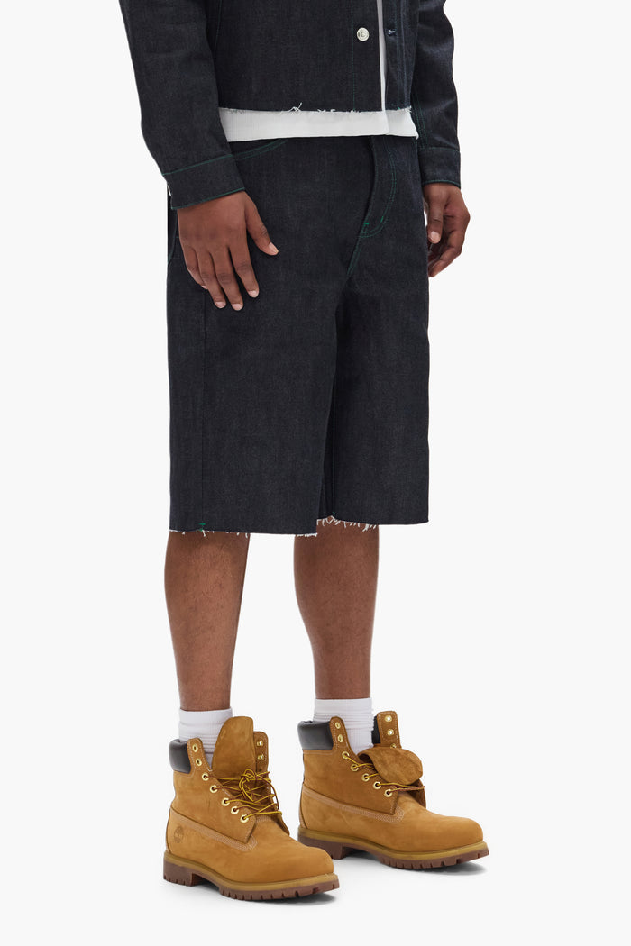 P070 Raw Shorts in Clean Dark Indigo with wide leg and raw cut hem features.