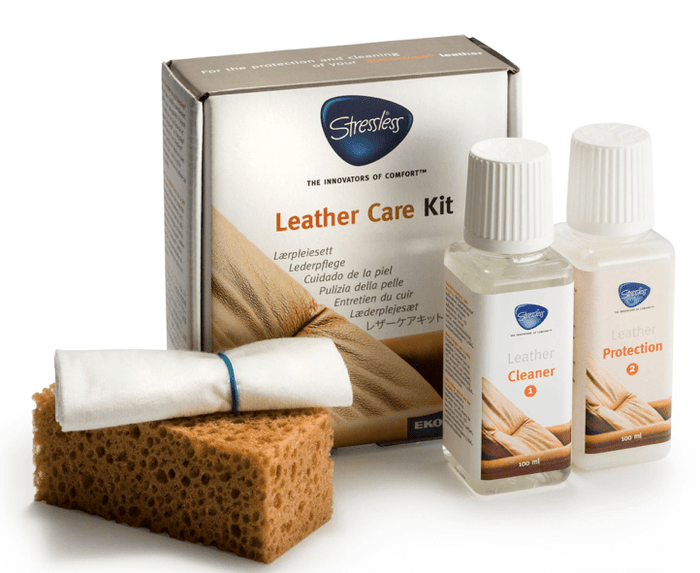 The Stressless Leather Kit by Stressless features a leather cleaner, protection wipes, yellow sponge, white cloth, and two bottles, all organized in a box on a white surface.